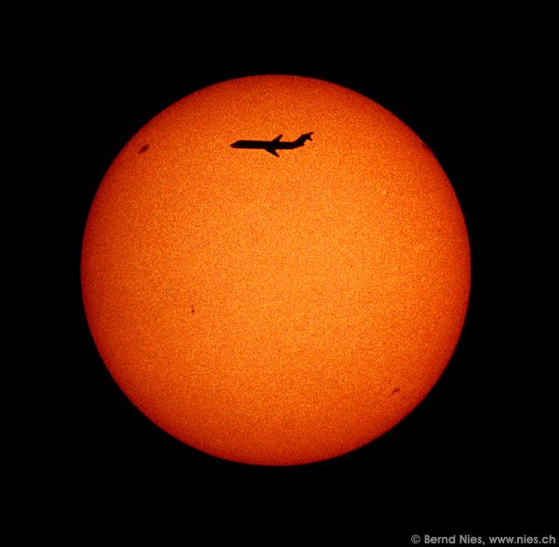 Airplane crossing sun