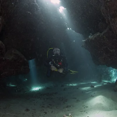 Cave Diver with Light Beams