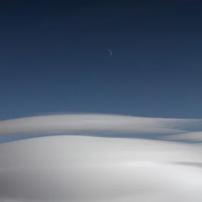 Moon above lenticular clouds